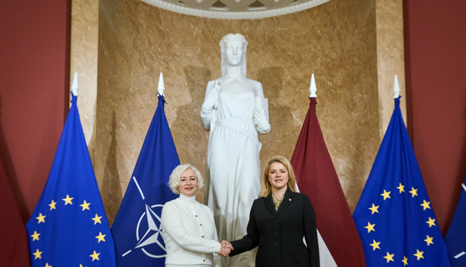 Ministru prezidente Evika Siliņa sarokojas ar Saeimas priekšsēdētāju Daigu Mieriņu pie Latvijas un Eiropas Savienības karogiem Ministru kabineta ēkā