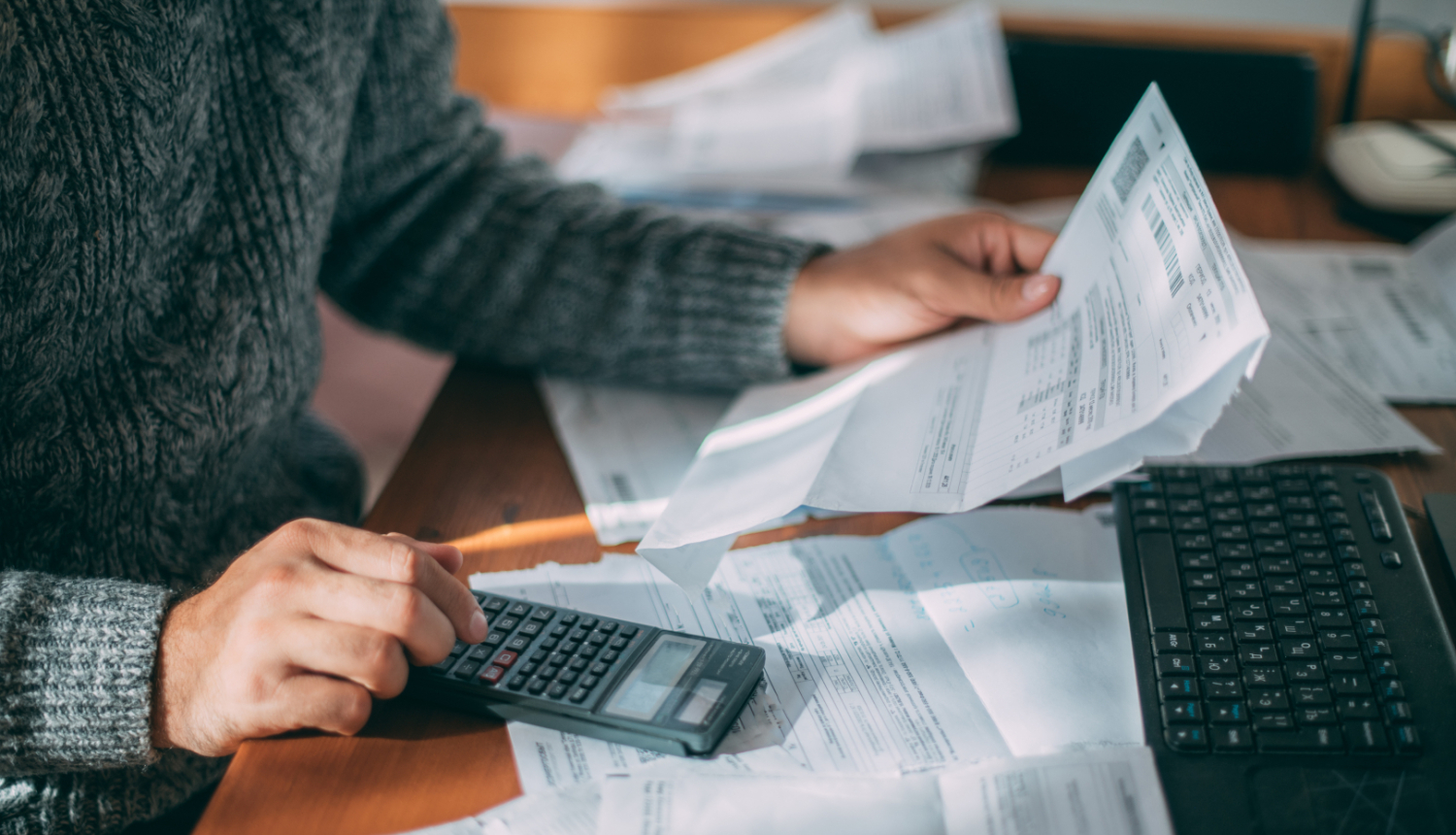 Vizualizācija, kurā persona uz kalkulatora rēķina izmaksu tabulas