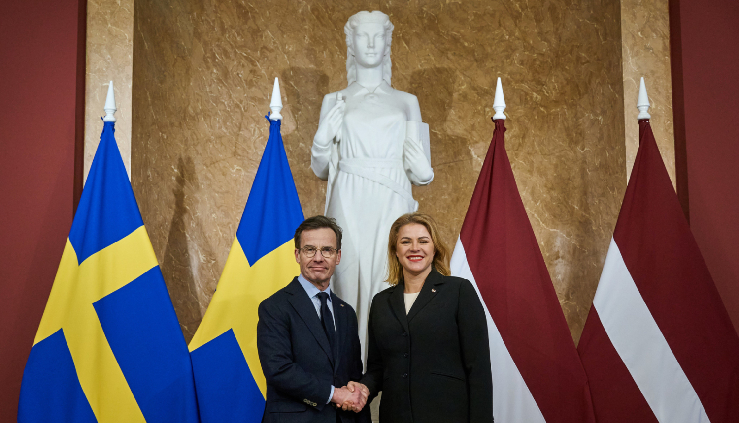 Ministru prezidente Evika Siliņa sarokojas ar Zviedrijas premjerministru Ulfu Kristersonu pie abu valstu karogiem Ministru kabinetā