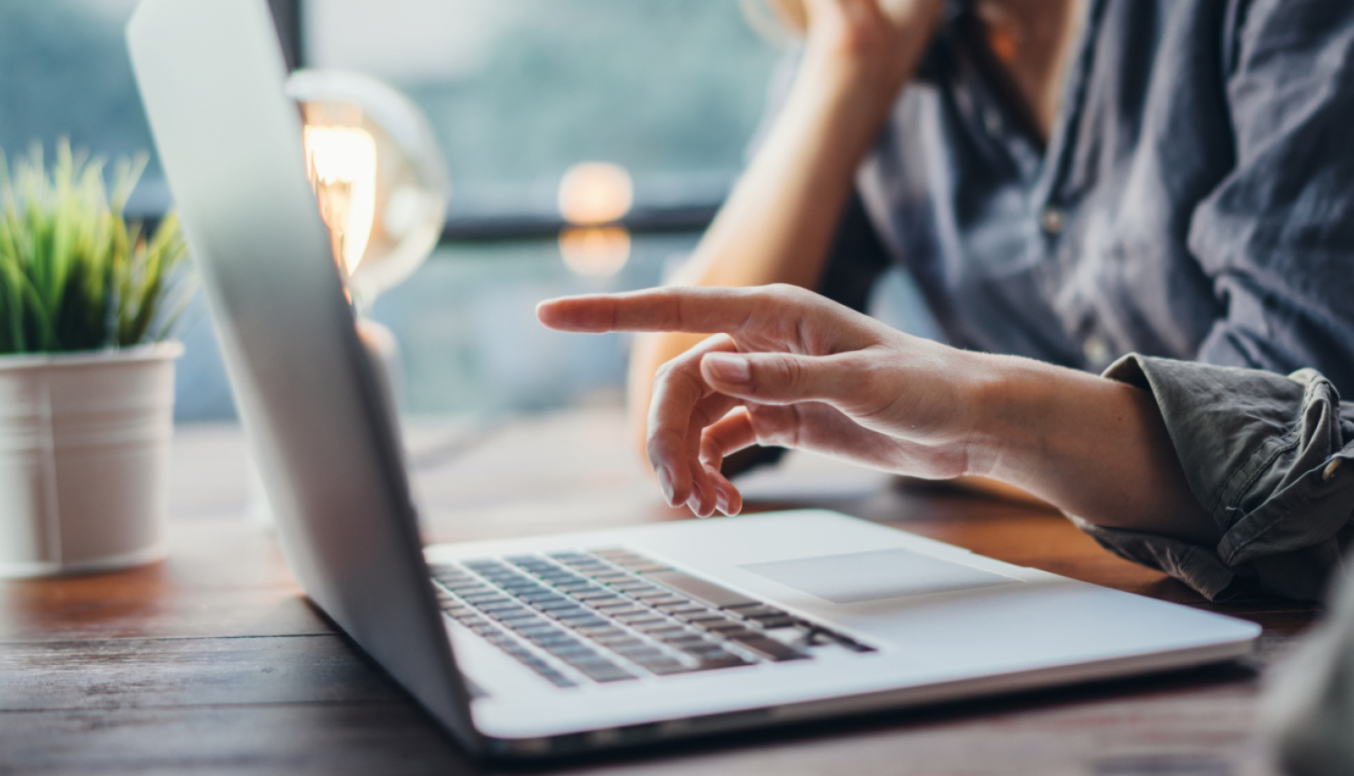 Cilvēki pie galda pie atvērta klēpjdatora