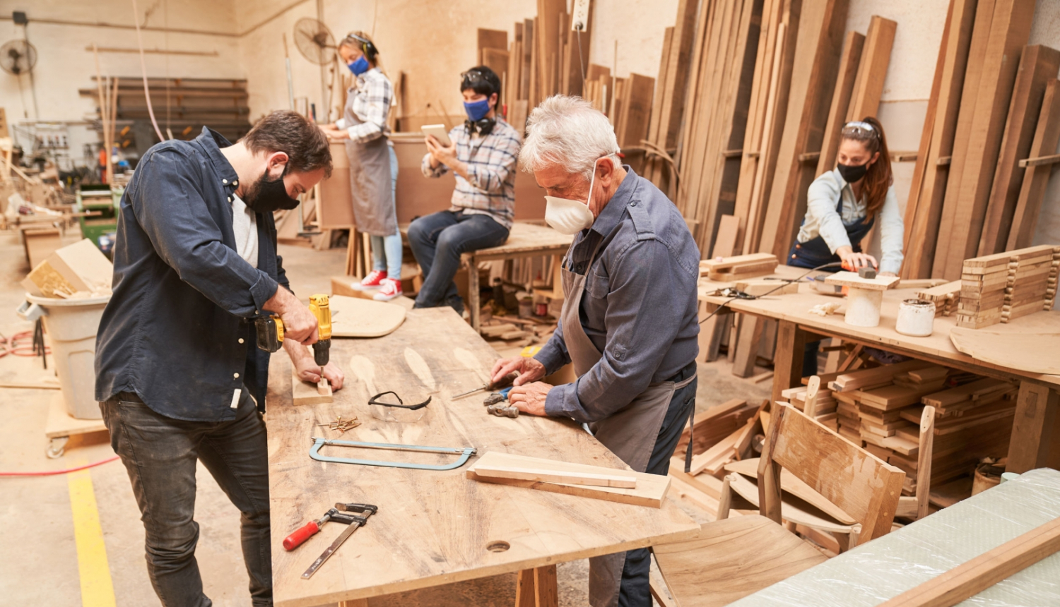 Cilvēki maskās strādā ar koku