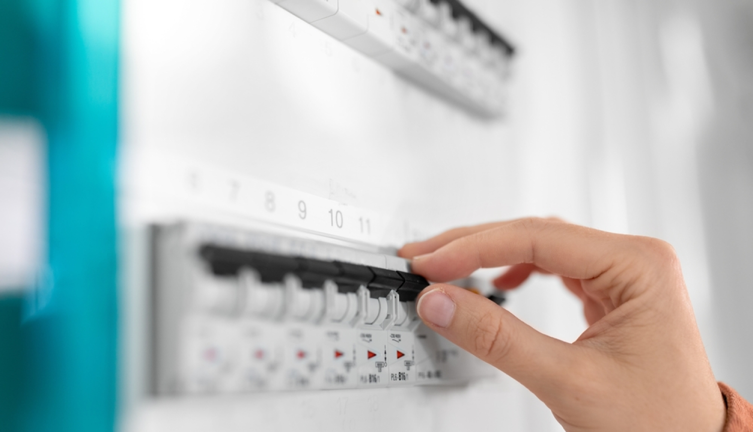 Cilvēka roka tuvplānā slēdz elektrības slēdzi