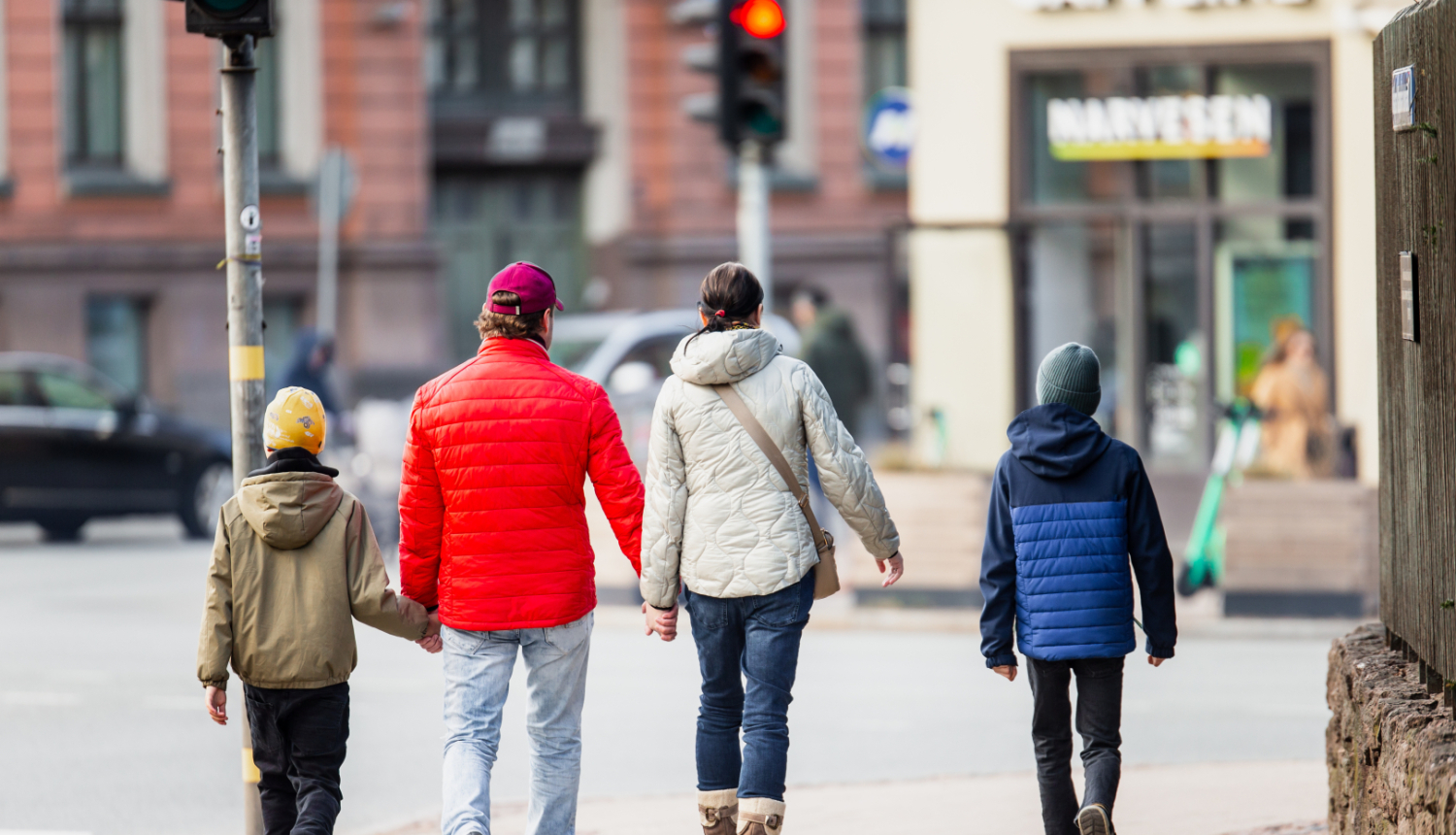Ģimene - vecāki un divi dēli - iet pa ielu