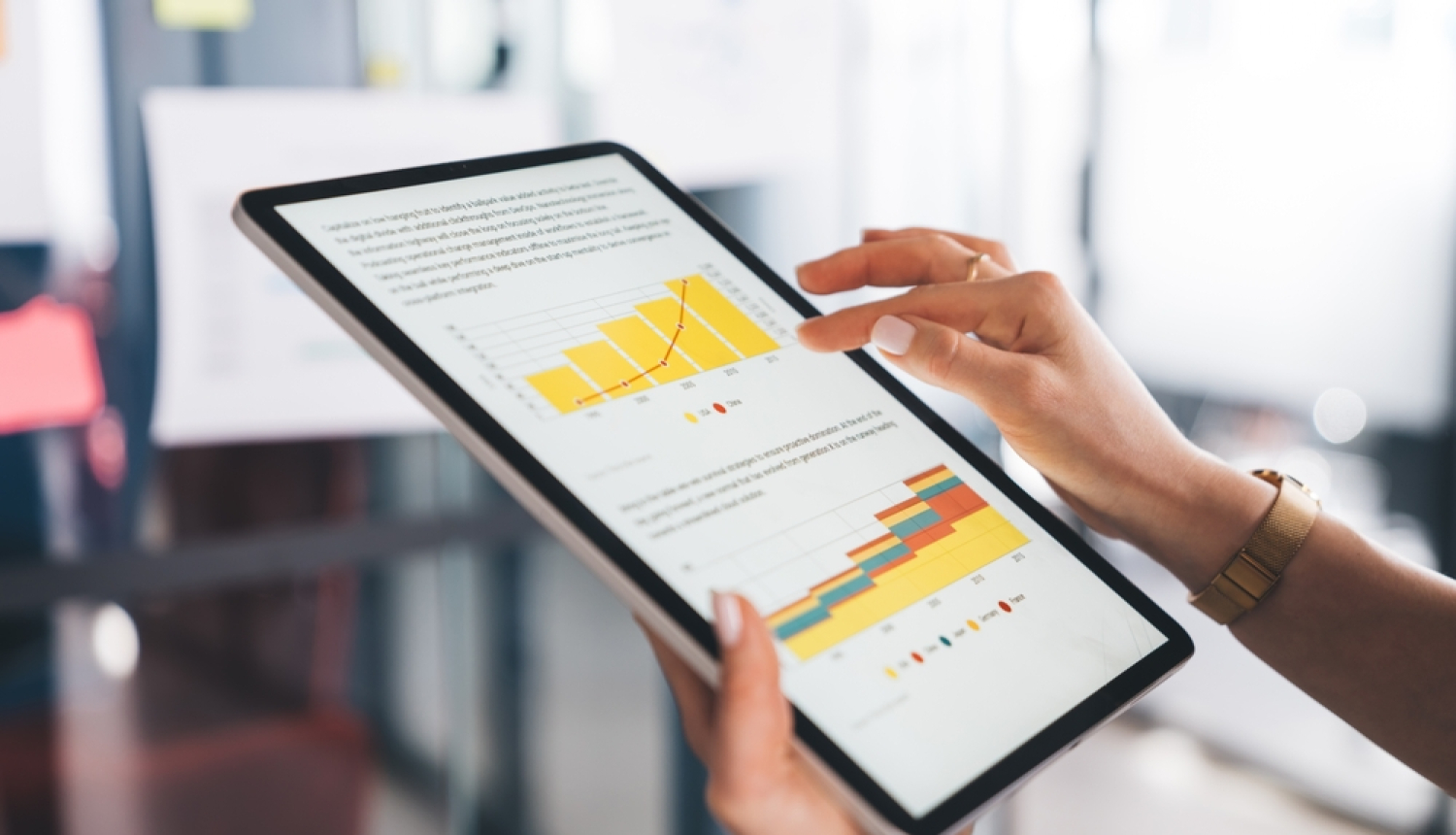 Planšetdators ar grafikiem cilvēka rokā