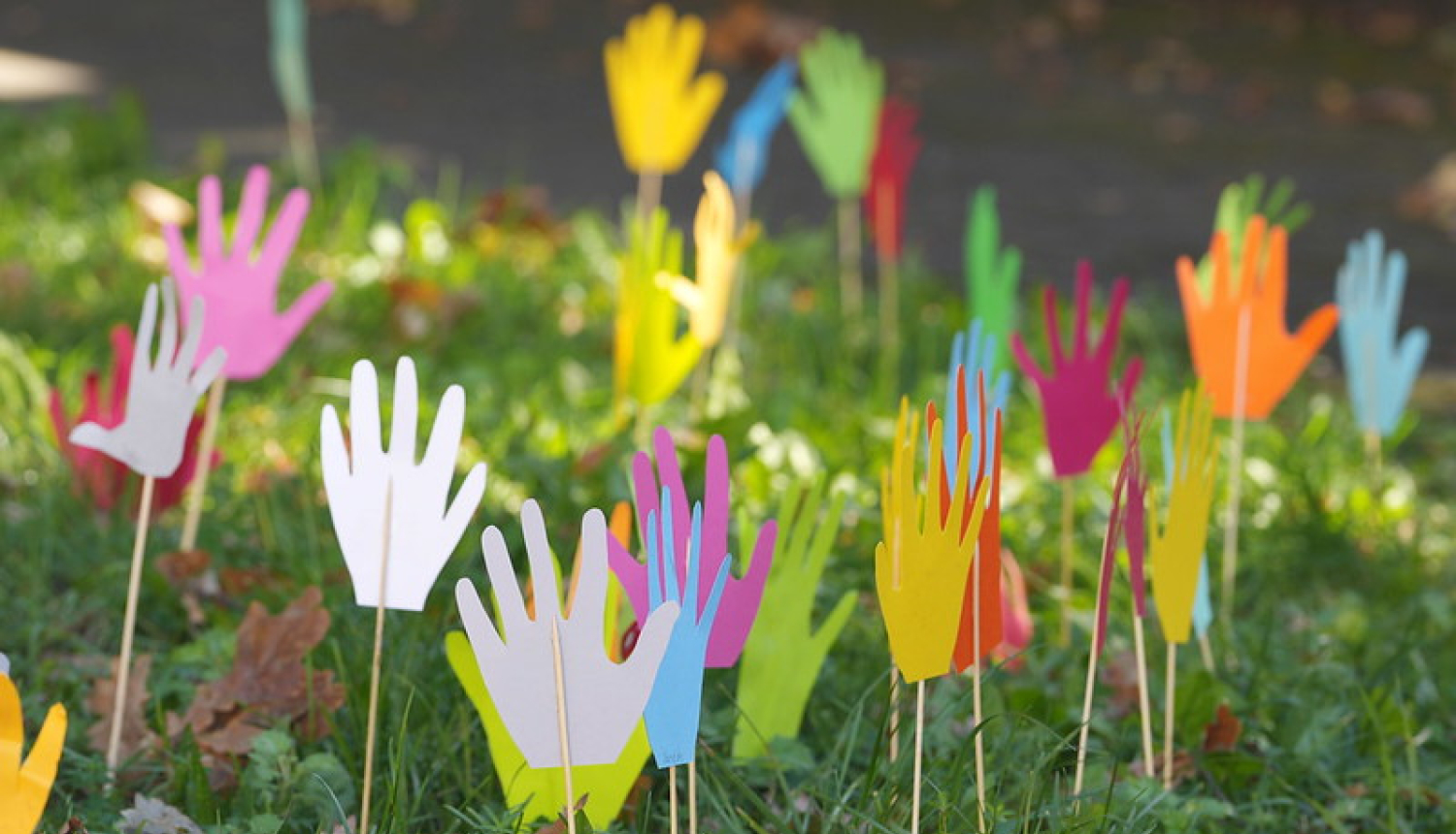 Zālē saspraustas bērnu veidotas rociņas no krāsaina papīra. Foto no KIVAS programmas atklāšanas pasākuma. 
