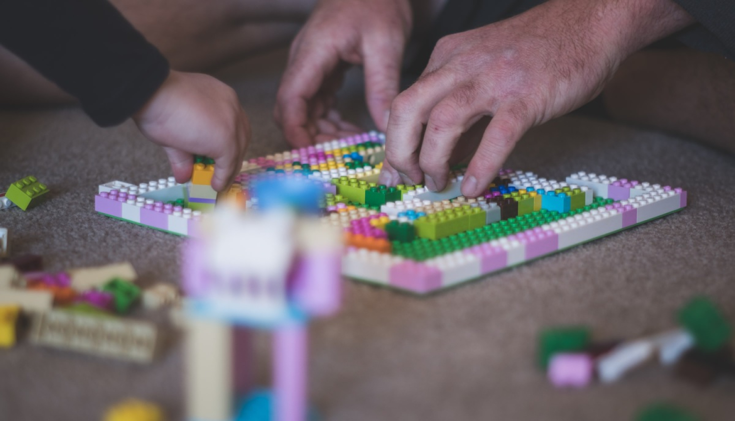 Tētis un bērns spēlē Lego spēli