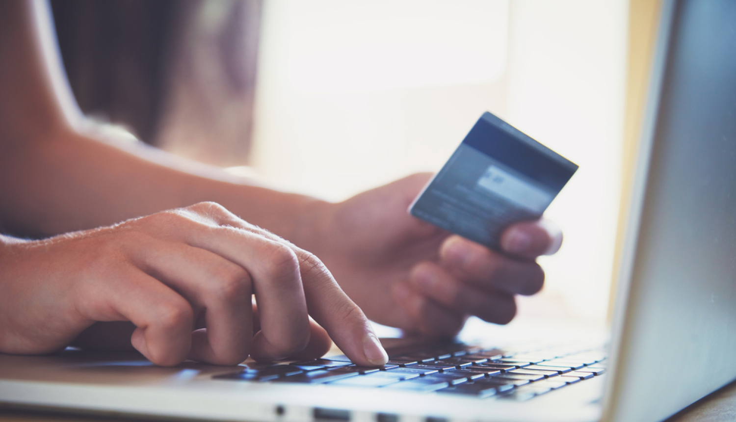 Cilvēks norēķinās ar karti, izmantojot datoru