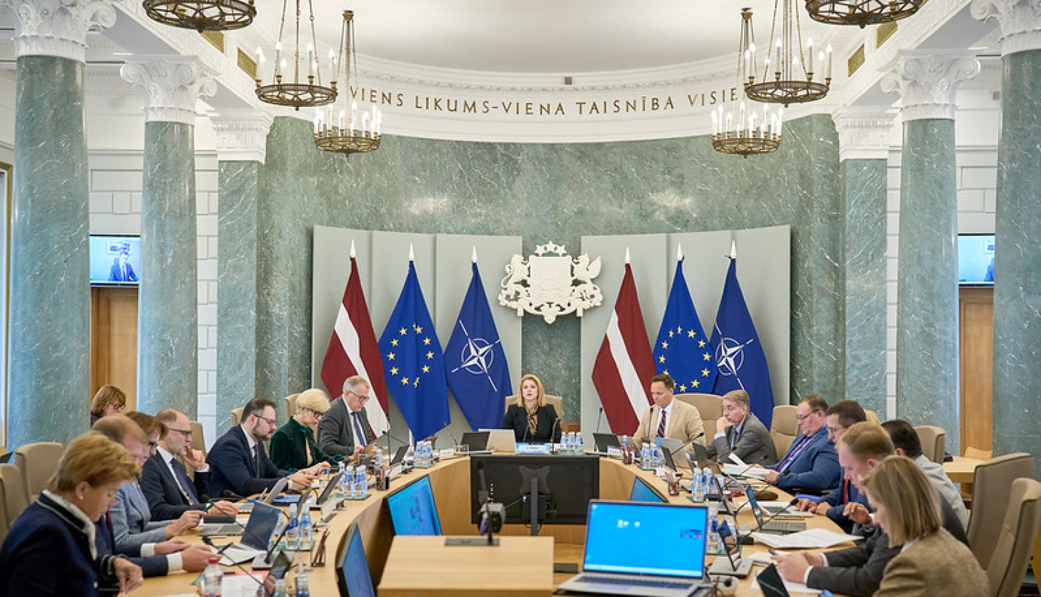 Foto no |Ministru kabineta sēdes 8. oktobrī. Sēdes dalībnieki sēž ap galdu Zaļajā zālē. 