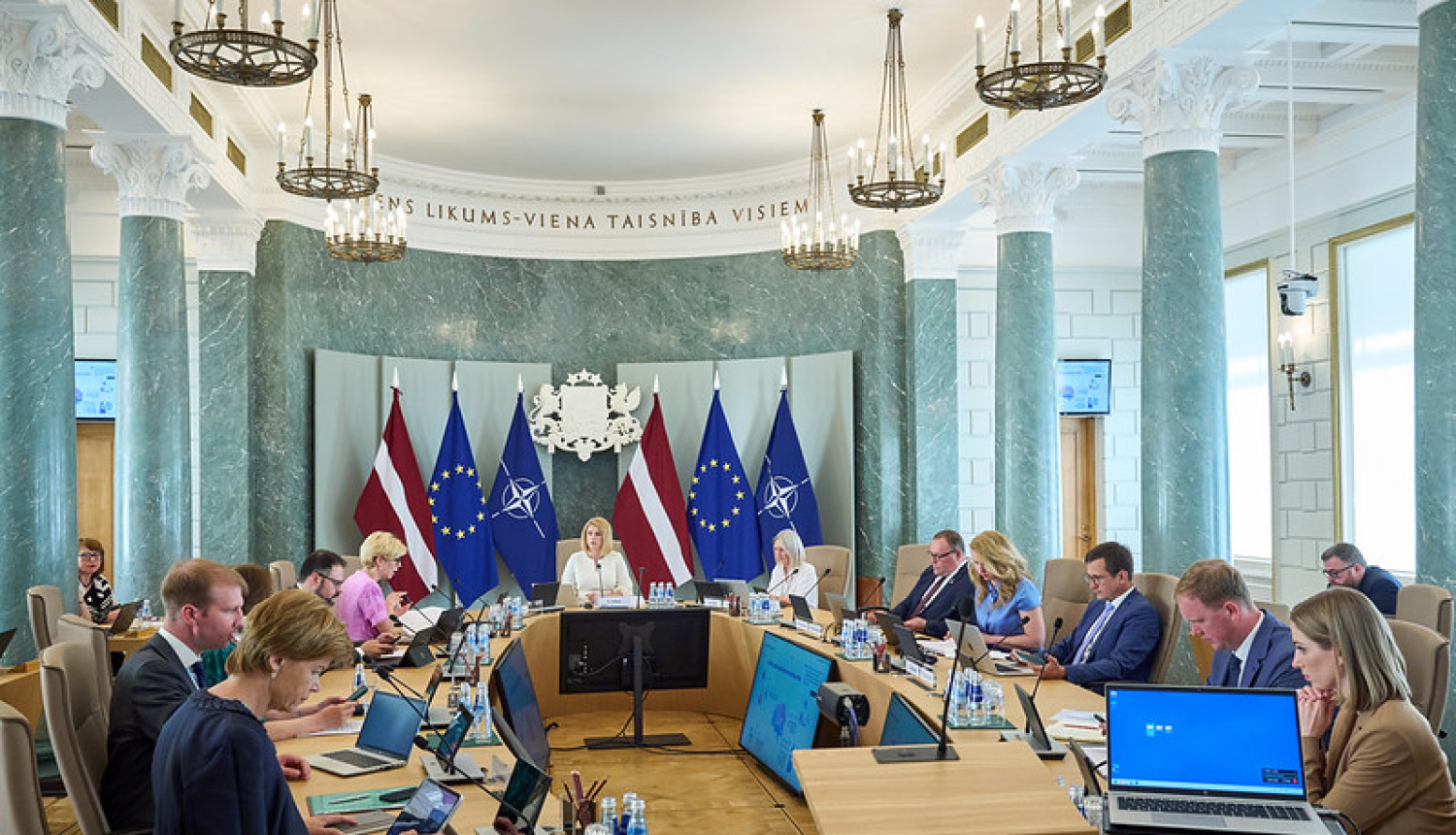 Ministru kabineta sēde. Ministri un Ministru prezidente sēž savās darba vietās pie sēžu galda. 