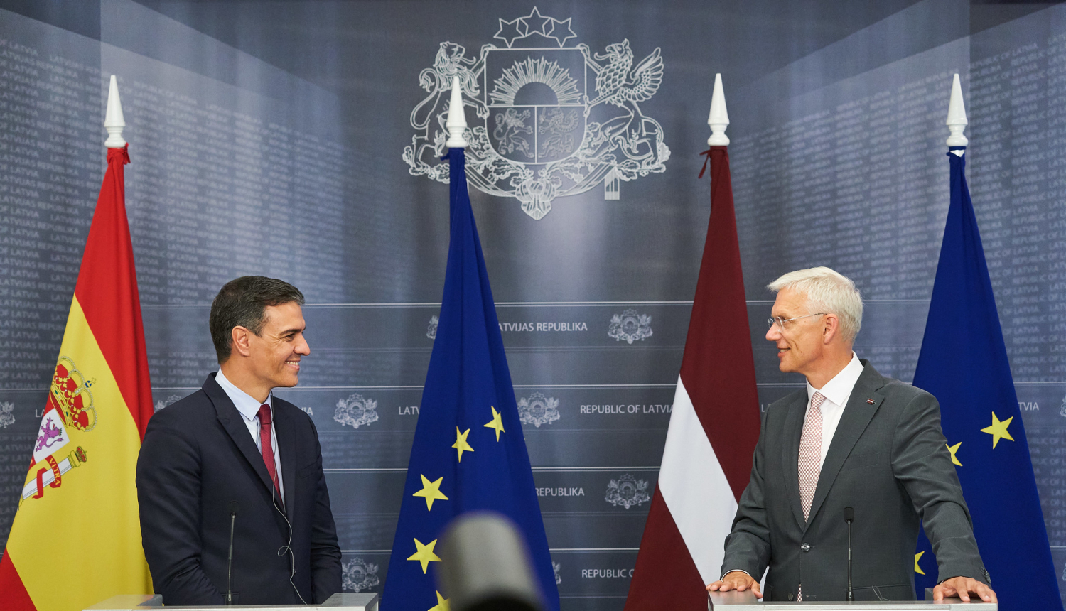 Spānijas premjerministrs Pedro Sančess un Latvijas premjerministrs Krišjānis Kariņš, fonā Eiropas Savienības un abu valstu karogi