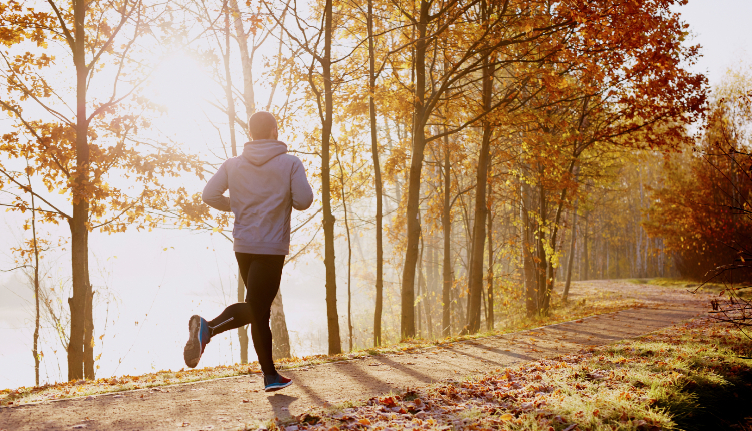 Skrējējs skrien pa celiņu rudens rītā