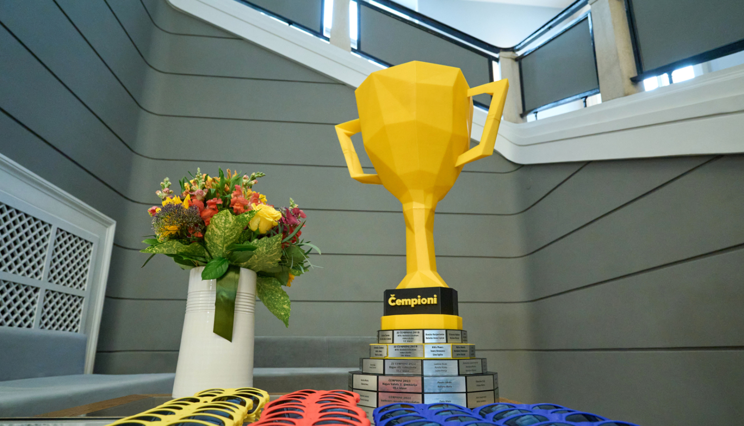 ČēČēČempionāta uzvarētāju kauss un saulesbrilles ar dažādu krāsu rāmīšiem uz galda Ministru kabineta vestibilā