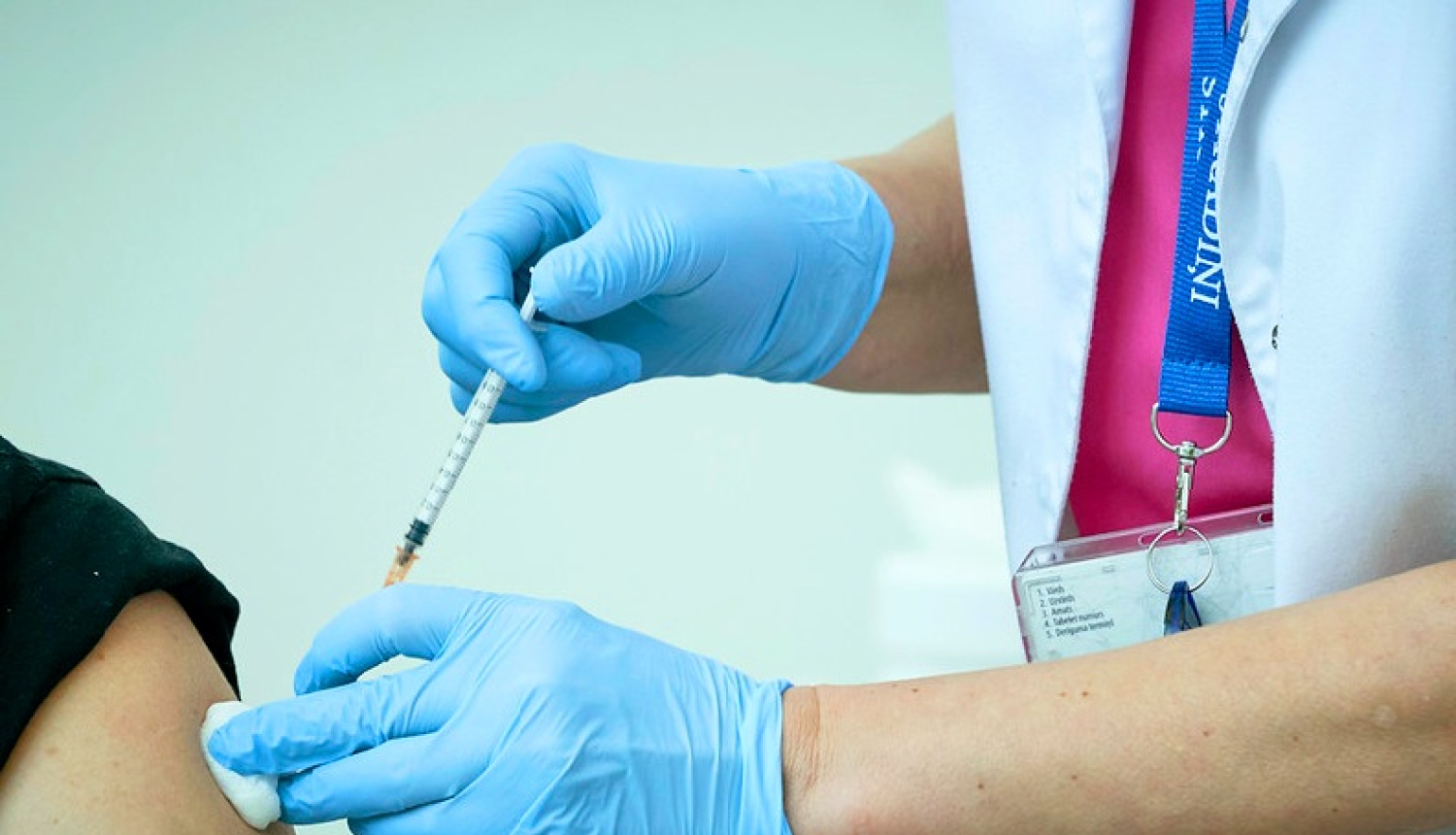 Cilvēks tiek vakcinēts plecā