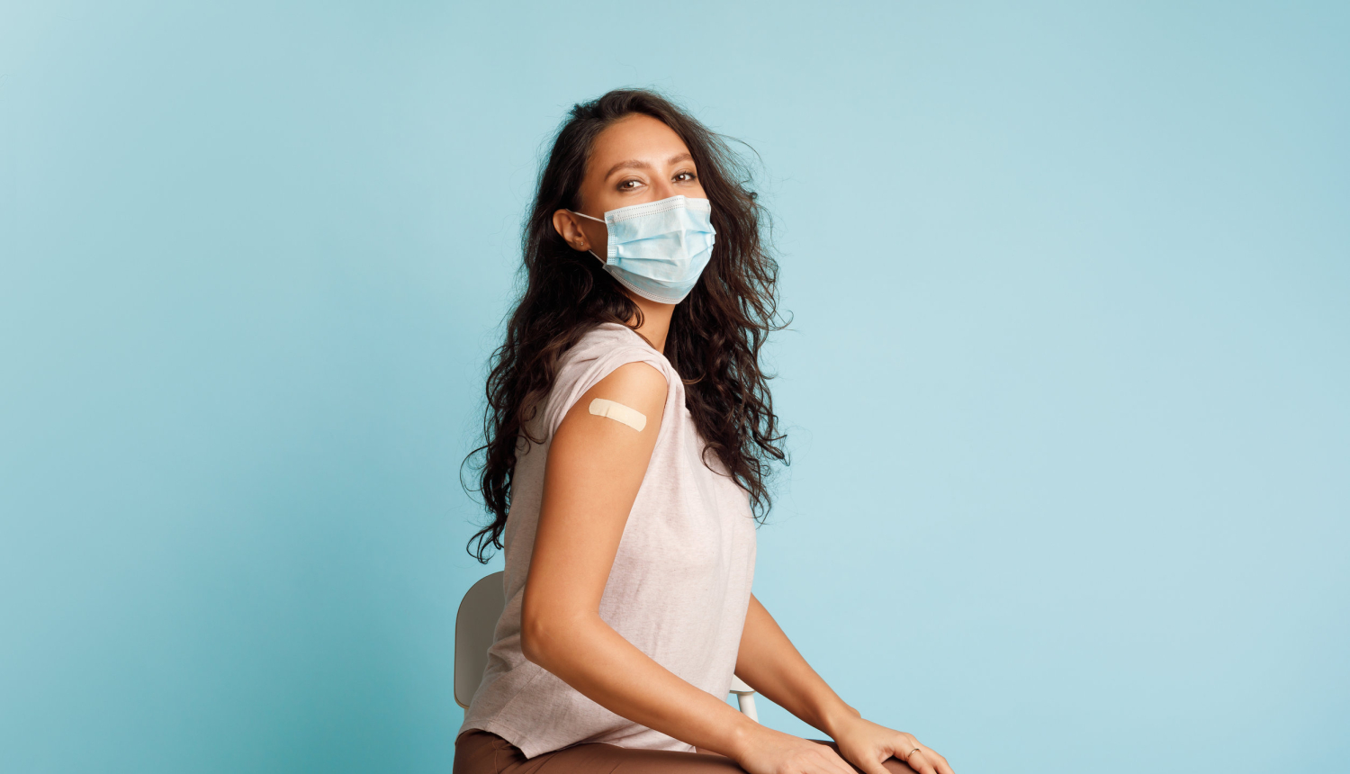 Vakcinēta sieviete ar plāksteri uz pleca