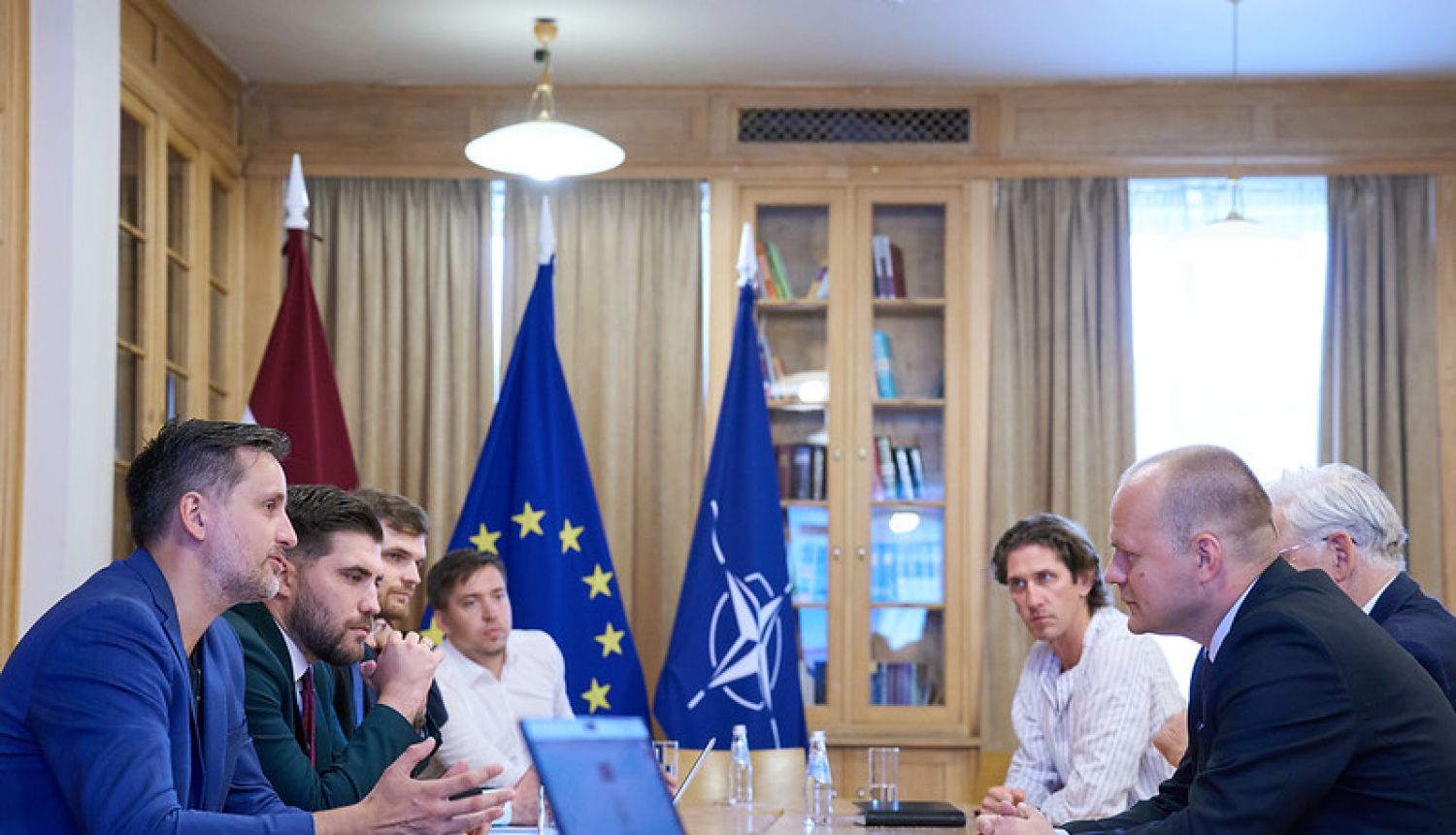 Valdības un Saeimas pārstāvji sēž ar sporta nozares pārstāvjiem pie galda Ministru kabineta bibliotēkā. 