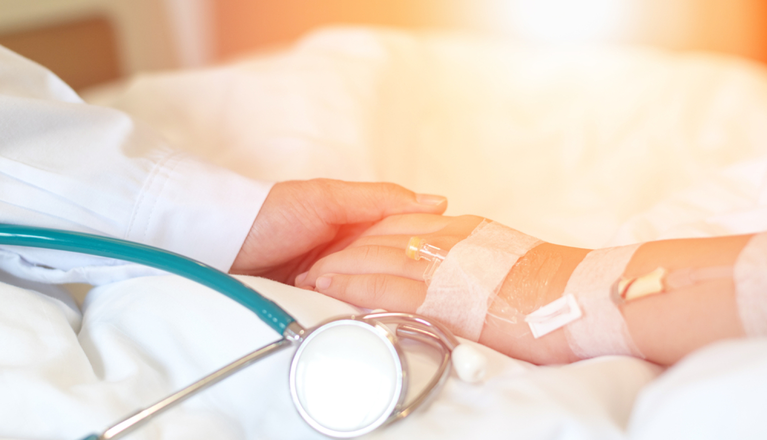 Ārsts tur pacienta roku.