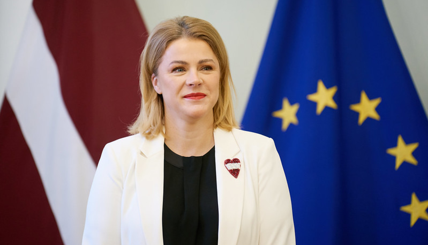Ministru prezidente uz Latvijas un Eiropas Savienības karoga fona