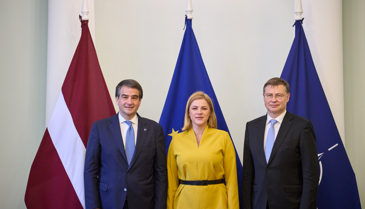 Fotogrāfijā pie Latvijas, Eiropas Savienības, NATO karogiem no labās Eiropas Komisijas priekšsēdētājas izpildvietnieks kohēzijas un reformu jautājumos Rafaēle Fito, Ministru prezidente Evika Siliņa, Eiropas Komisijas priekšsēdētājas izpildvietnieks jautājumos par ekonomiku Valdis Dombrovskis