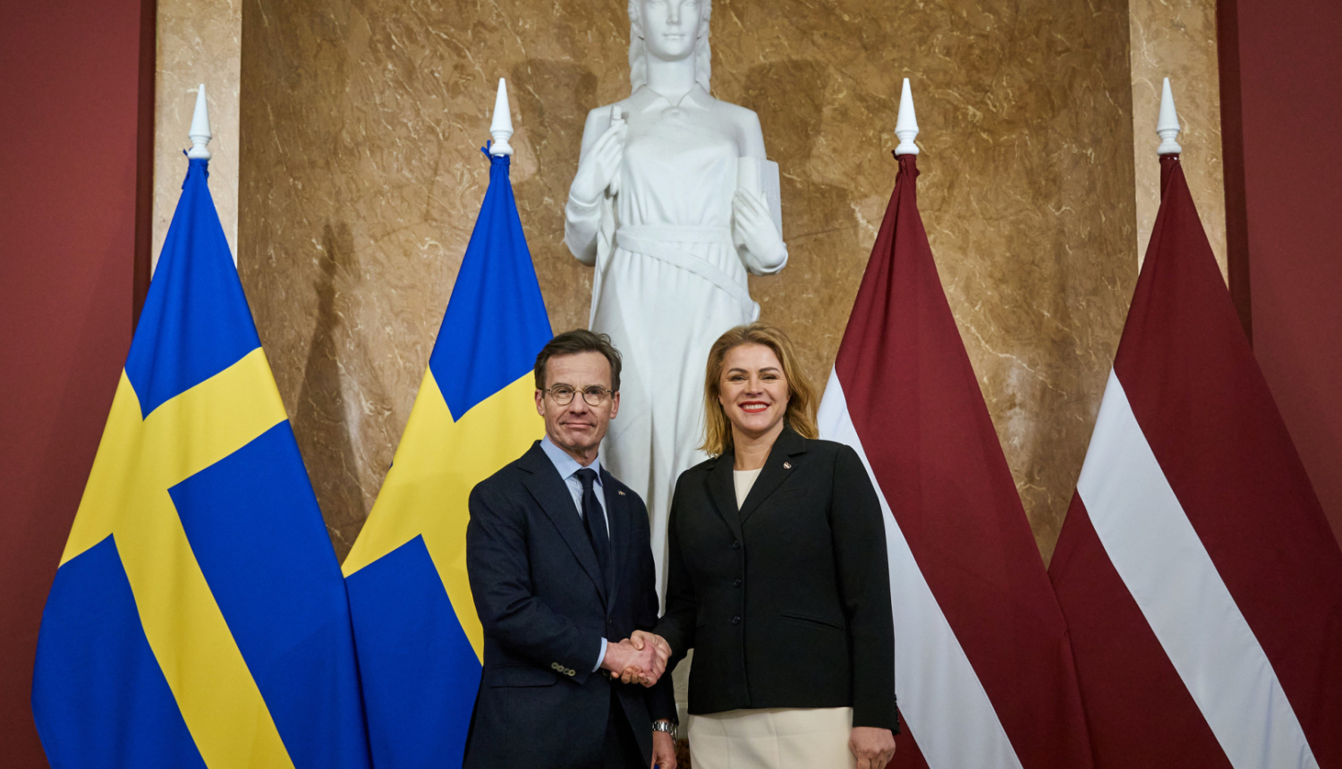 Ministru prezidente Evika Siliņa sarokojas ar Zviedrijas premjerministru Ulfu Kristersonu pie abu valstu karogiem Ministru kabinetā