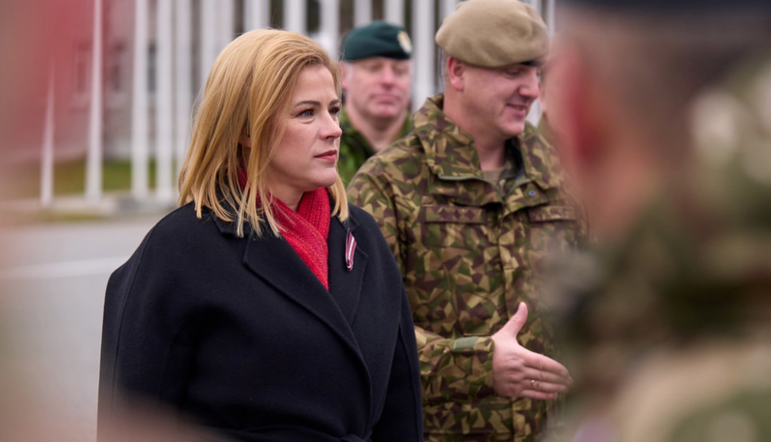 Ministru prezidente Evika Siliņa Ādažu militārajā bāzā, blakus premjerministrei militārpersonas.