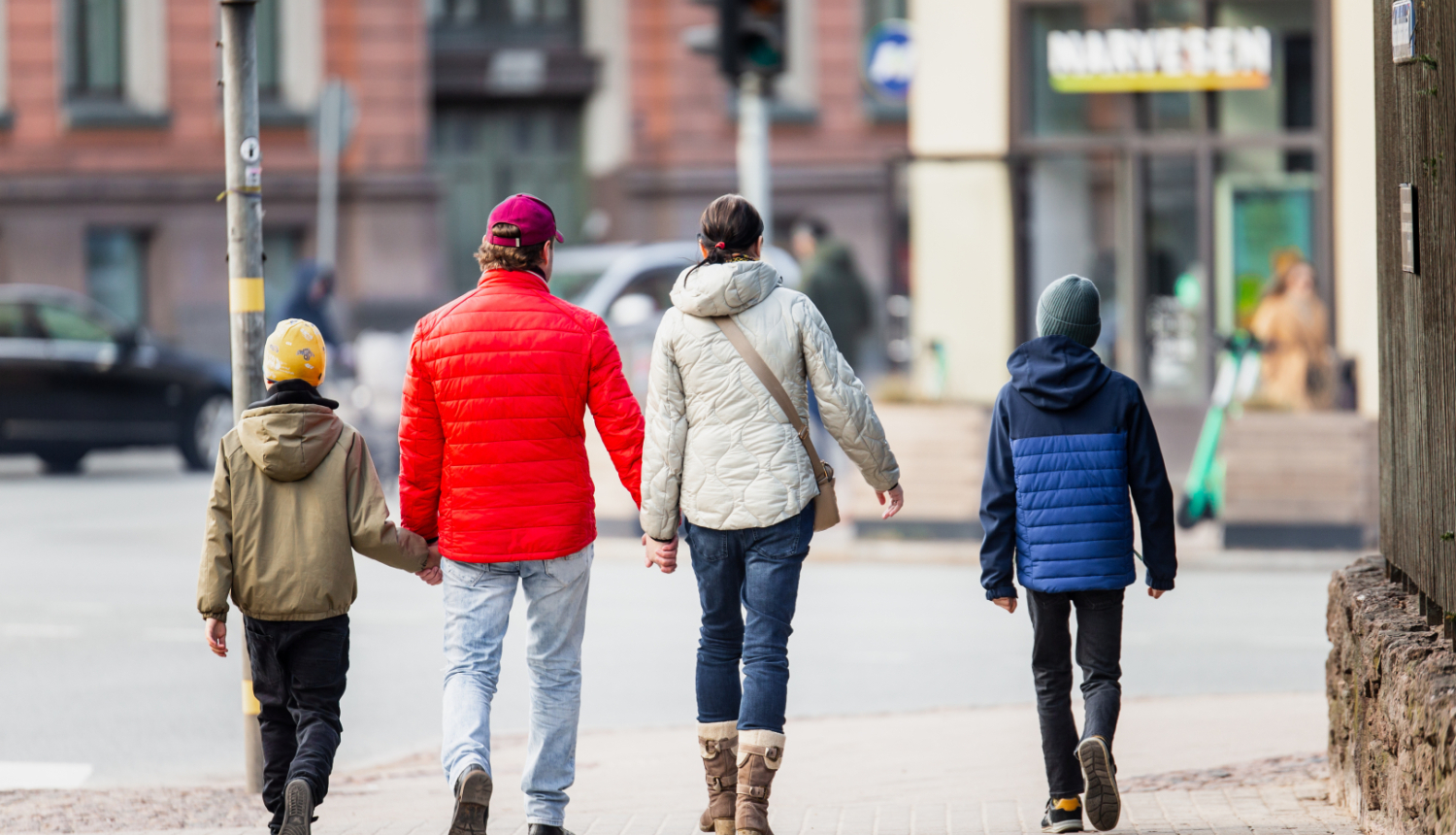 Ģimene - vecāki un divi dēli - iet pa ielu