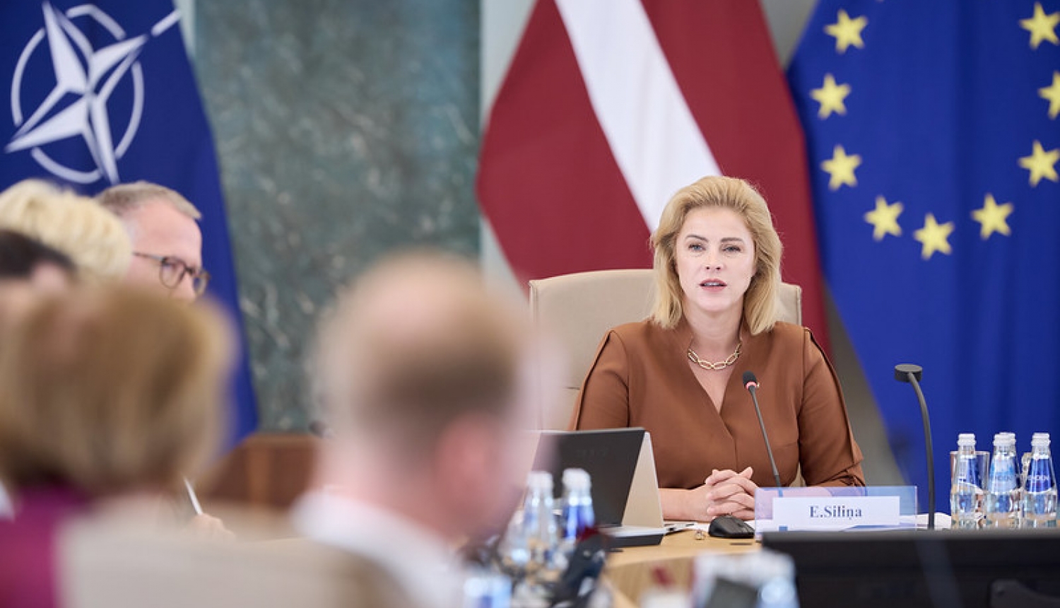 Ministru prezidente Evika Siliņa valdības sēžu zālē pie galda ar ministriem. 